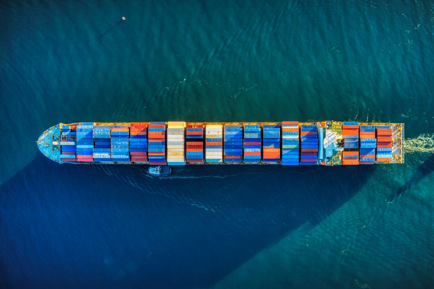 A loaded container ship at sea, seen from directly above