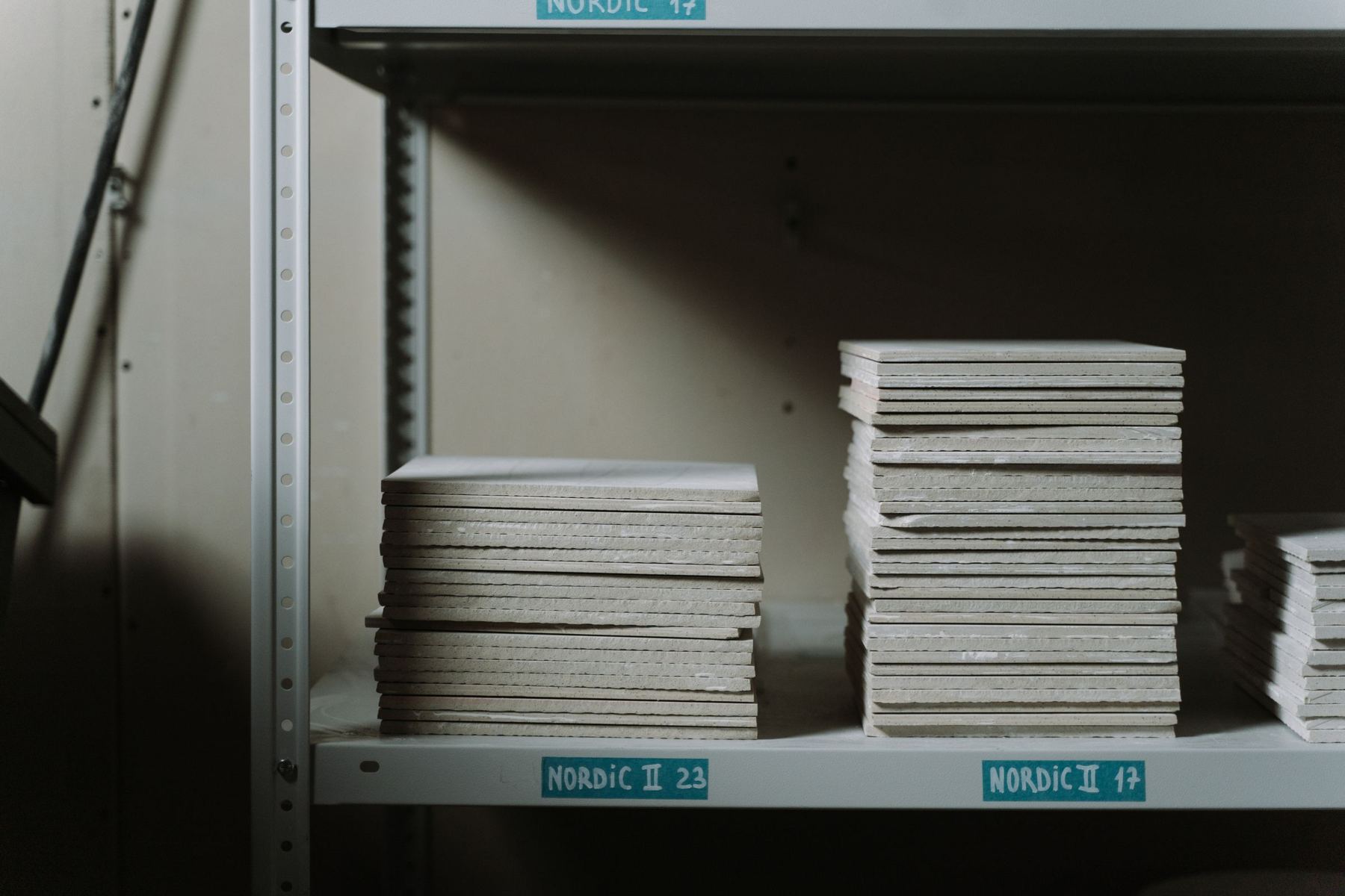 Stacks of unglazed tiles on factory shelving